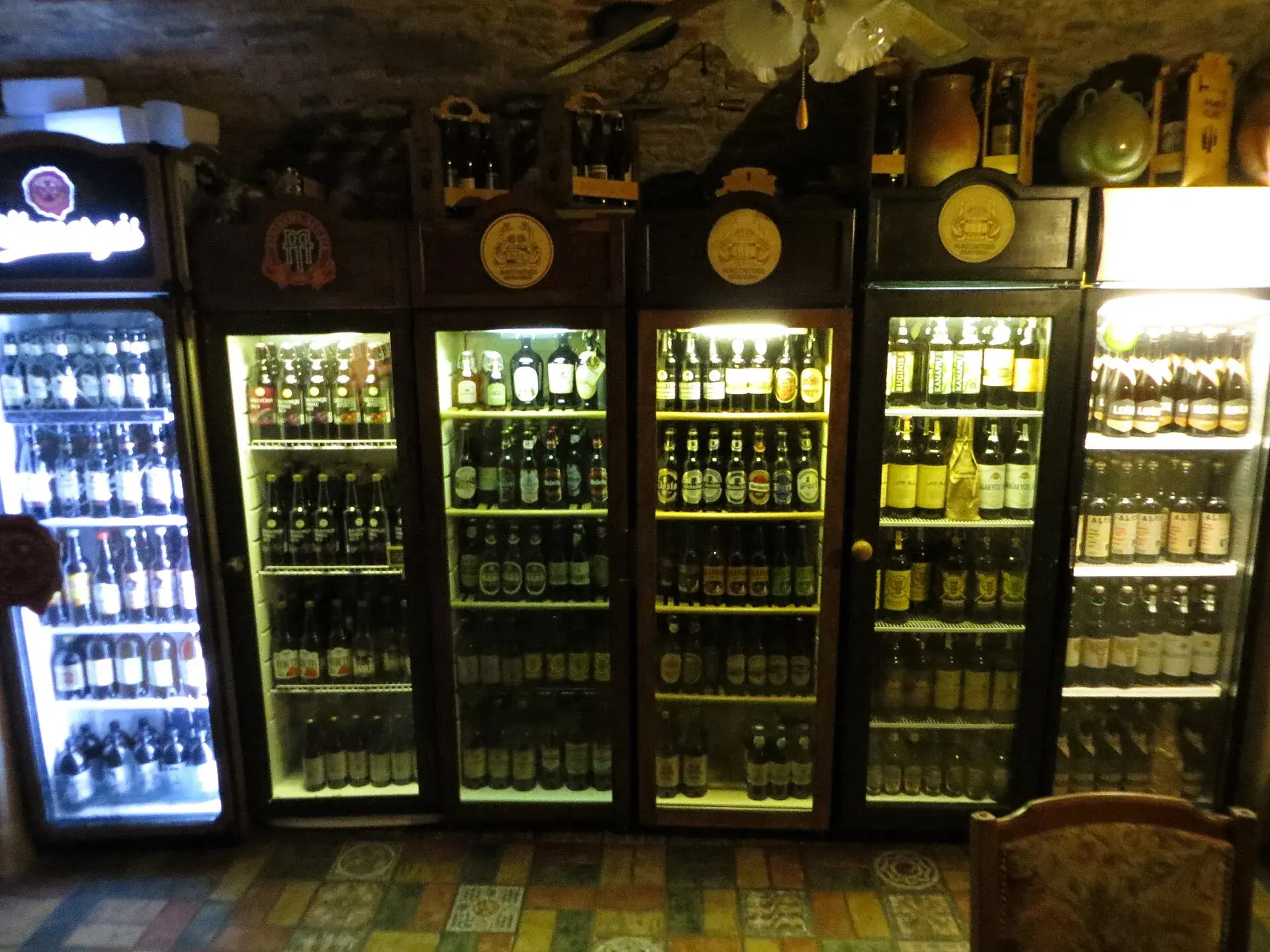 Glass-door bottle coolers behind a bar stocked with beer