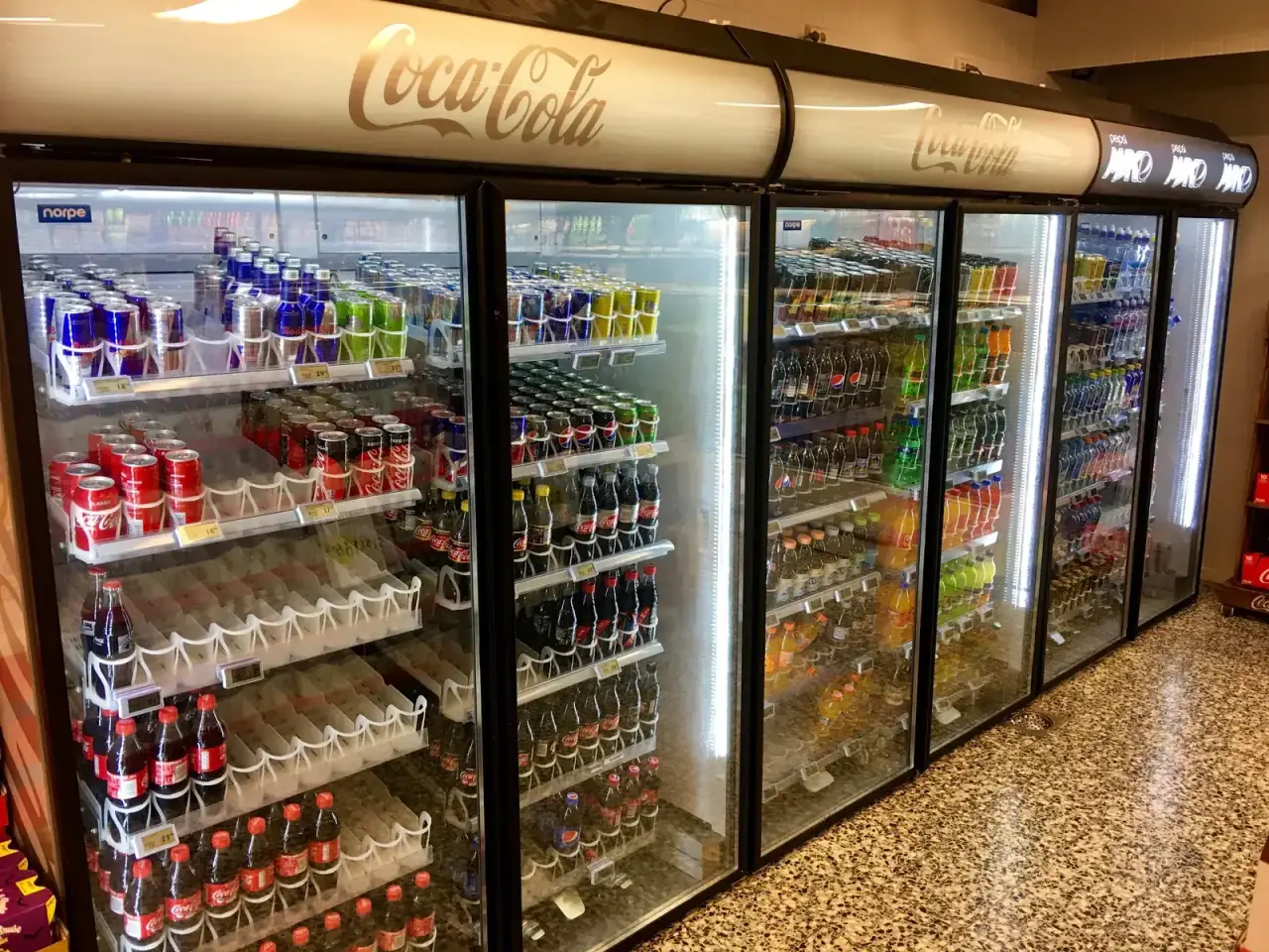Glass-door commercial refrigerators stocked with drinks in a store