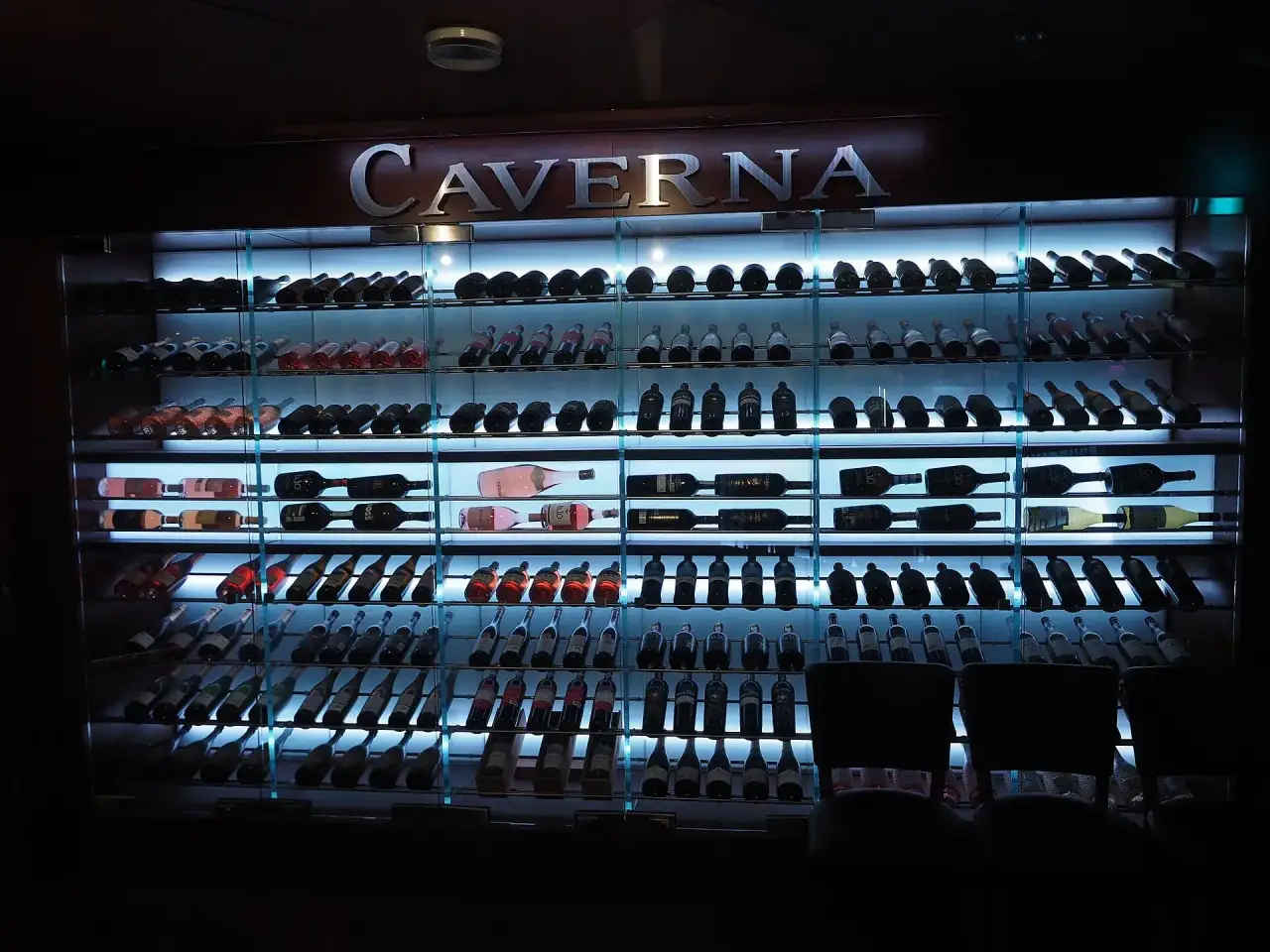 Backlit wine cooling cabinet with bottles stored on racks