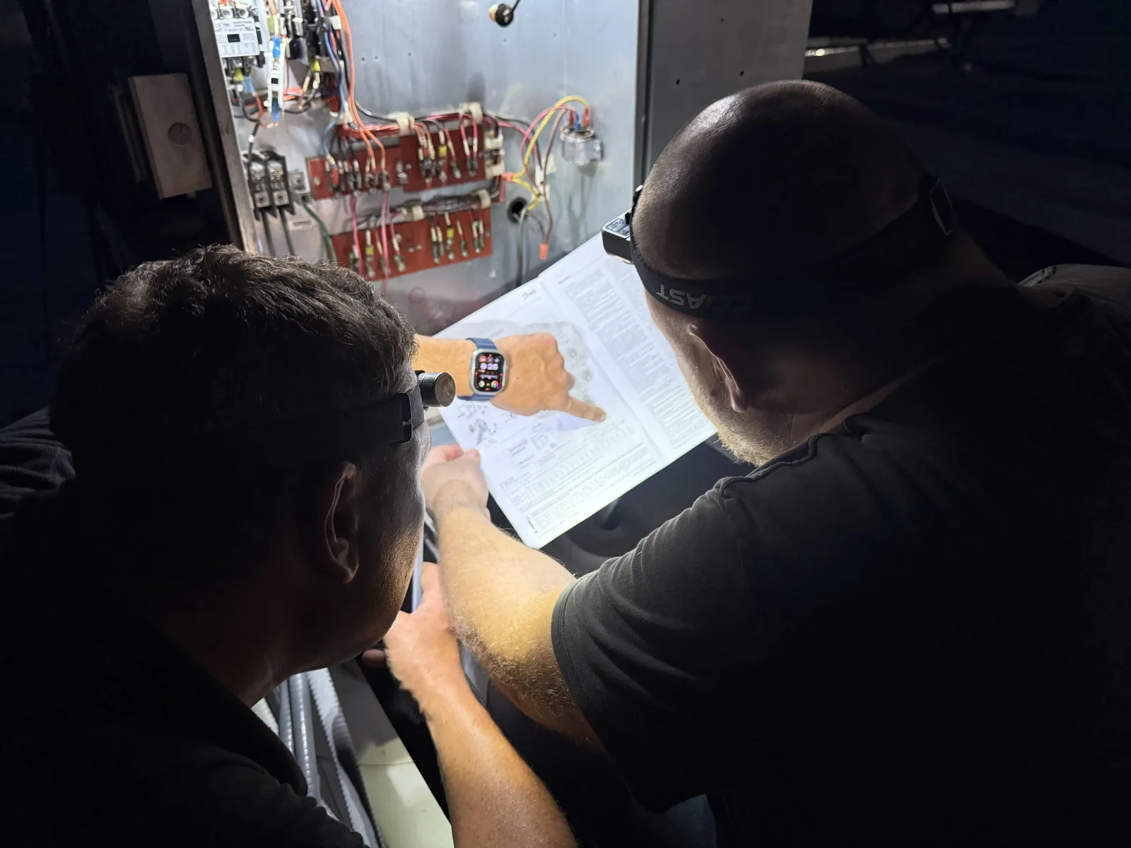 Doctor Fridge technicians reviewing a wiring diagram during a diagnosis
