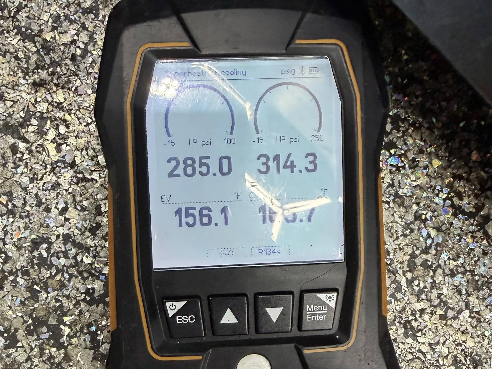 Digital manifold gauges reading refrigerant pressures on an air conditioner
